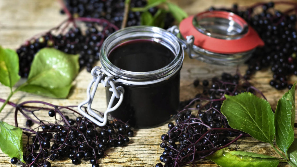 Elderberries and jar of elderberry syrup