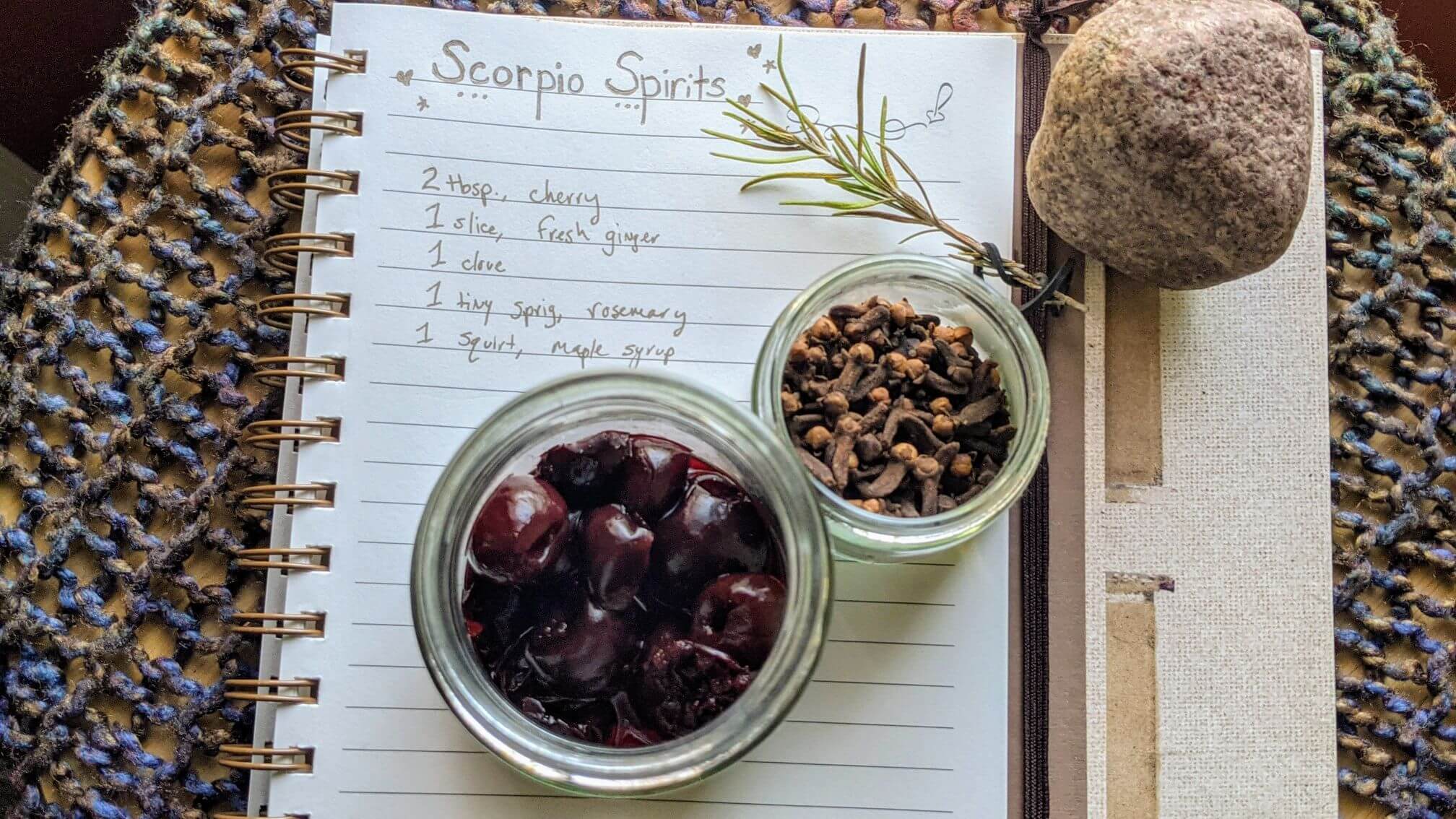 The handwritten recipe is displayed with an open jar for thawed, frozen cherries, whole cloves, and a sprig of fresh rosemary.